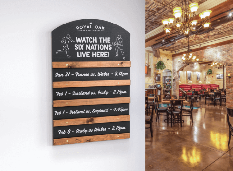 Sliding display chalkboard with sports screening information in a pub